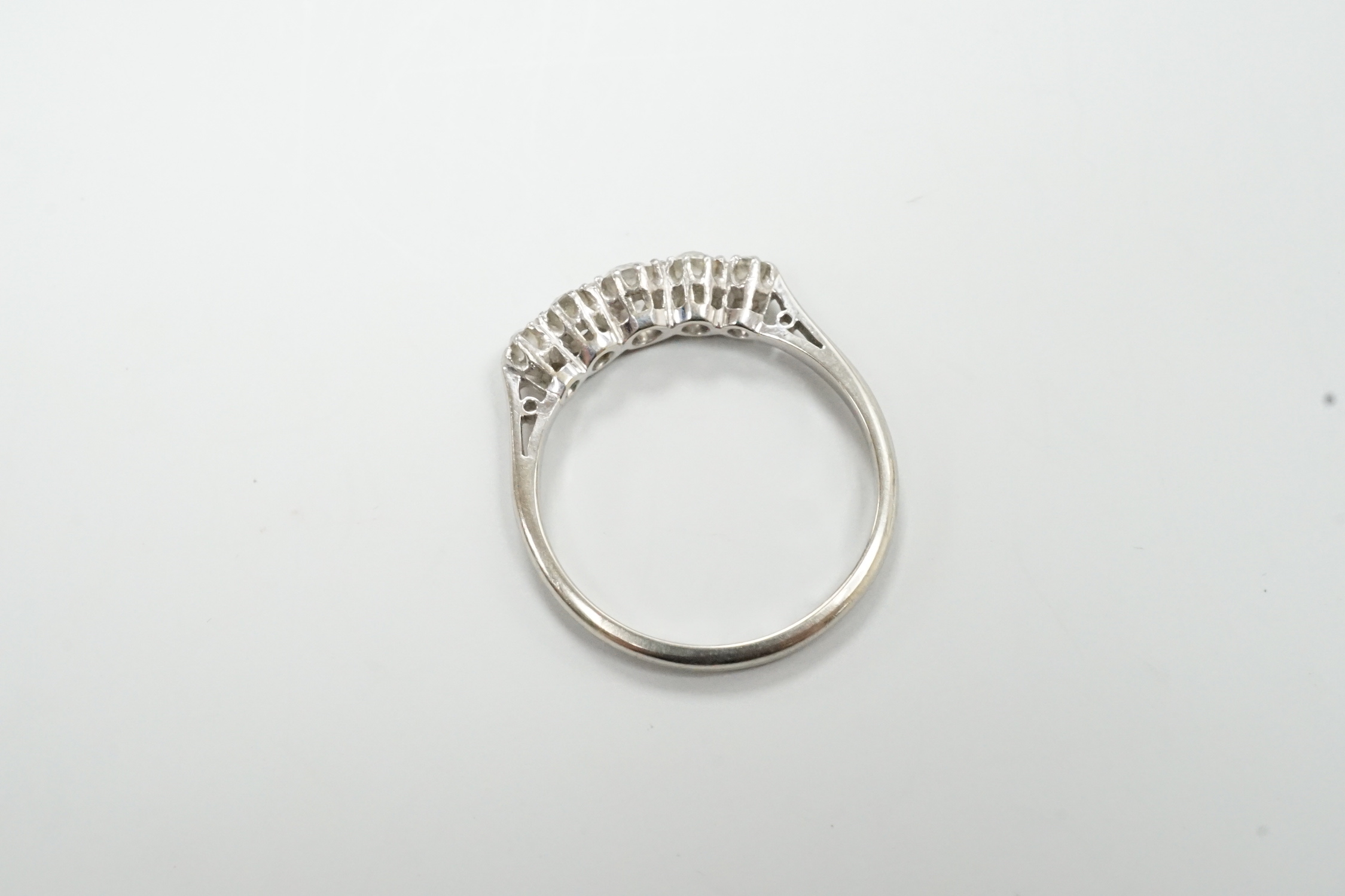A mid 20th century 18ct, plat and graduated five stone diamond set half hoop ring, size Q, gross weight 3 grams.